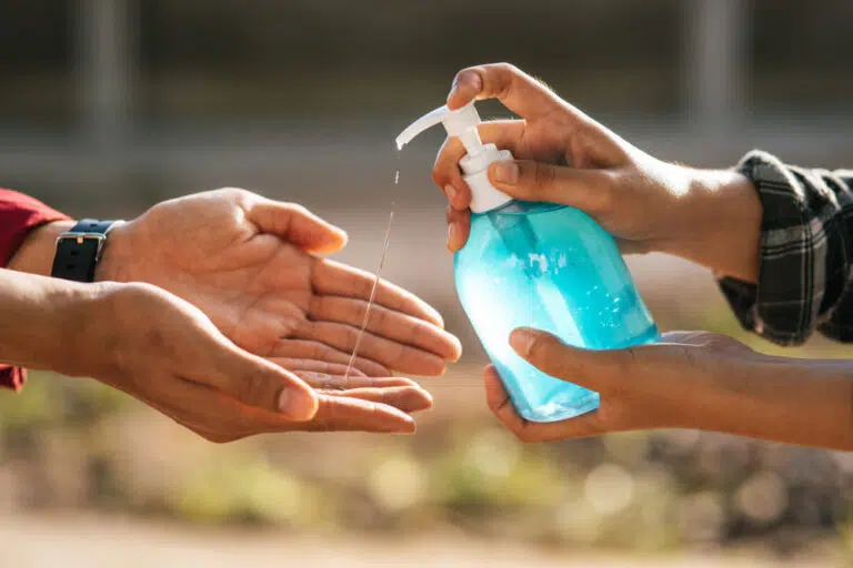 image of someone spraying sanitizer to another's hands