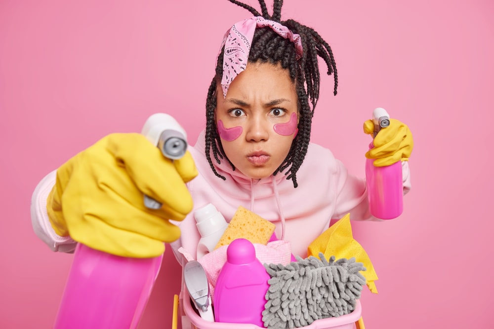 image of a young black woman holding spray bottles in both hands