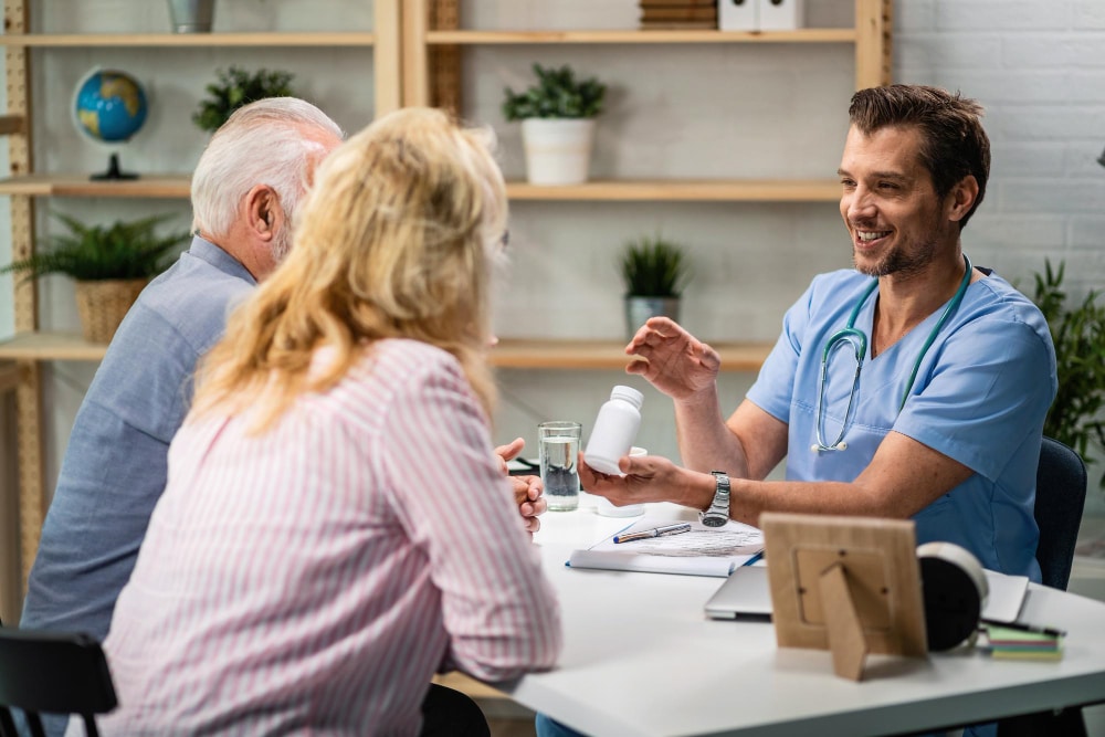 Image of a physician explaining to a couple with a plastic bottle in hand