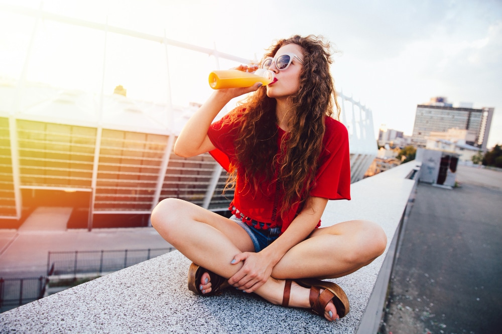 Image of a girl with a soft drink in her hand.