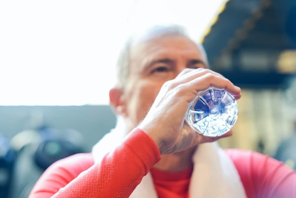 image of a man drinking water from a small water bottle