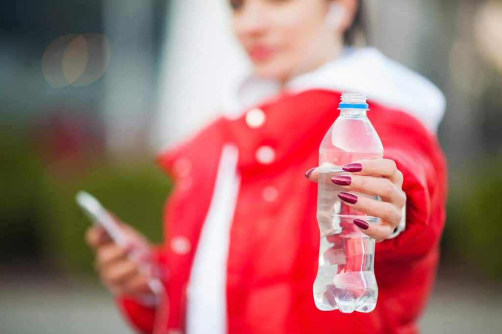Image of woman drinking from HDPE water bottle