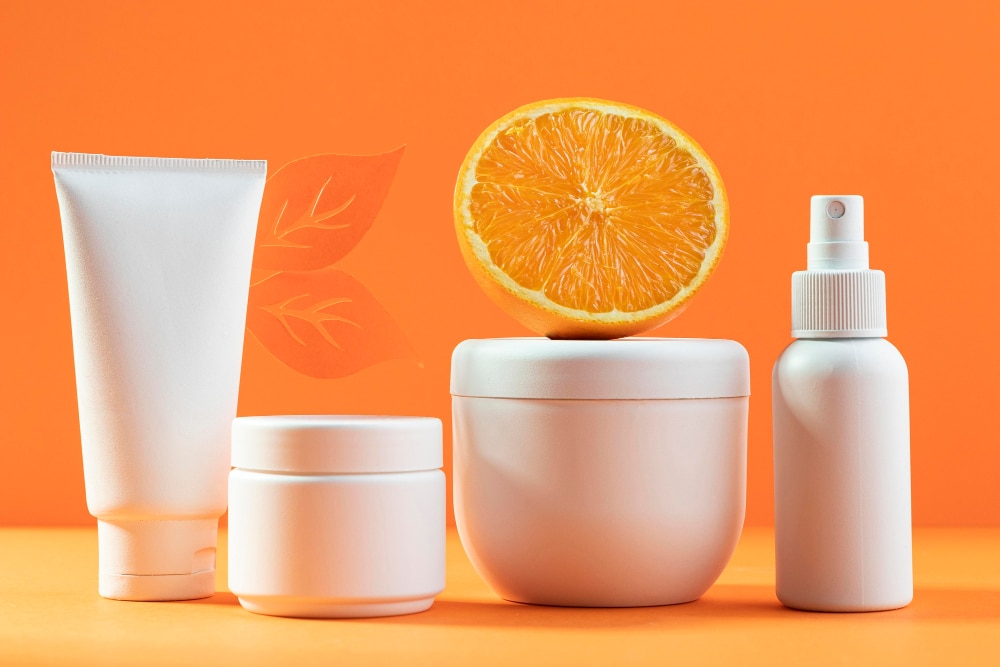 an image of white cosmetic packaging supplies with orange and orange background