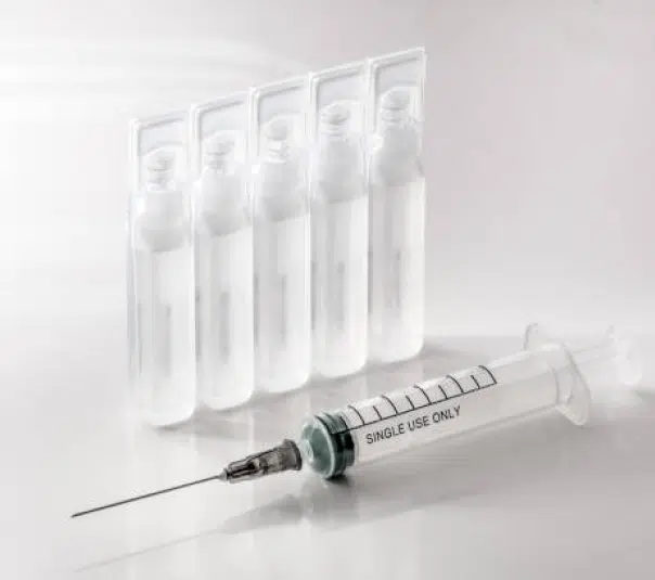 clear eye dropper bottles and an injection in front of it