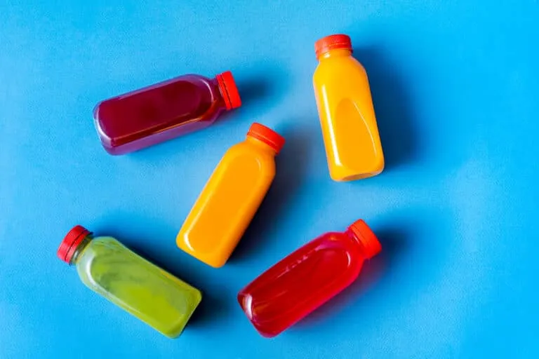 colorful Plastic Bottles with Lids on a blue surface