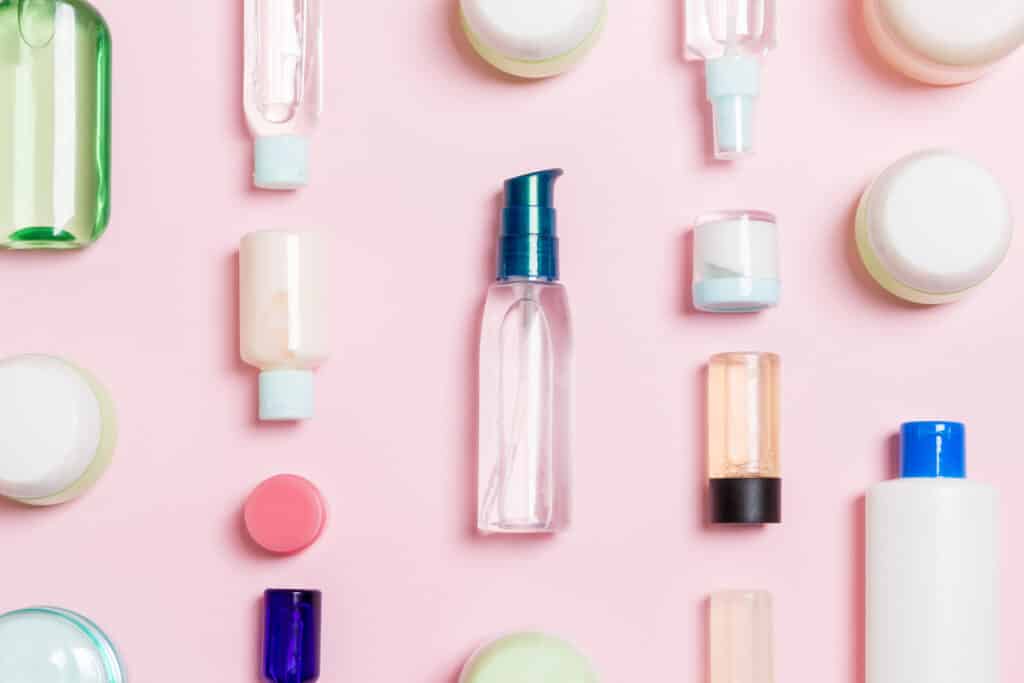 Group of plastic bodycare bottle Flat lay composition with cosmetic products on pink background empty space for you design. Set of White Cosmetic containers, top view with copy space.