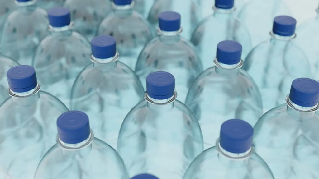 Empty plastic clean bottles for water with caps lids. Production of plastic bottles for.