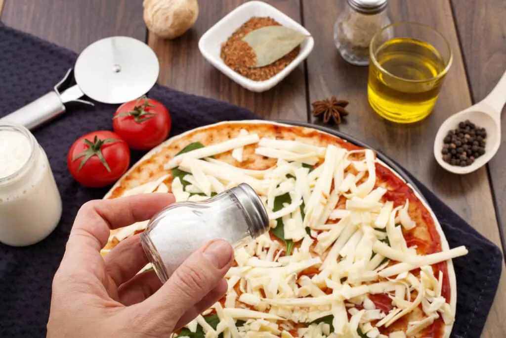 making pizza-add salt using condiment plastic bottles