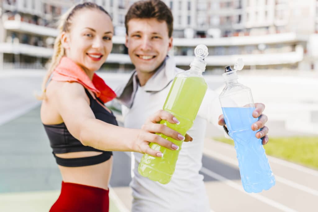 two sporty people using 32 oz plastic bottle to drink energy drink