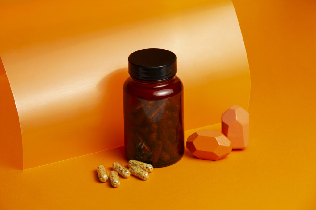 a brown plastic pill bottle in an orange background