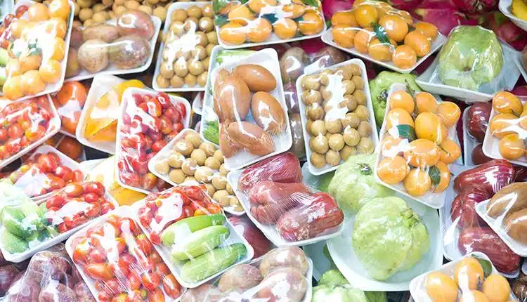 Different food packaged in plastic containers and wrapped. in polythene.