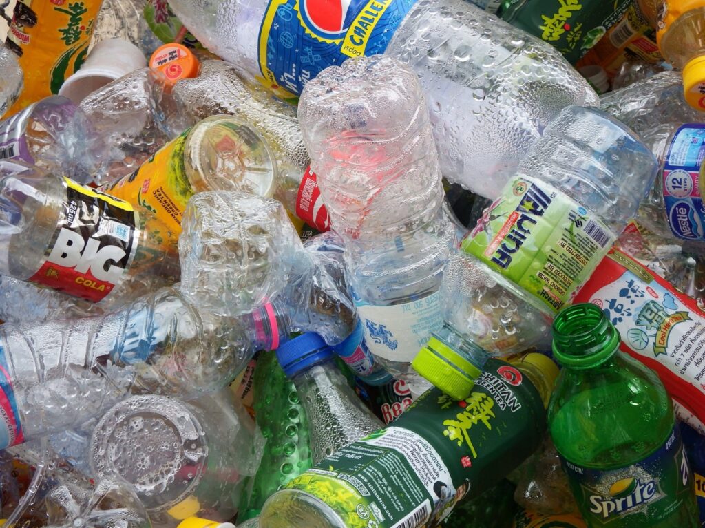 A pile of discarded PETE plastic bottles, showcasing various brands and sizes.