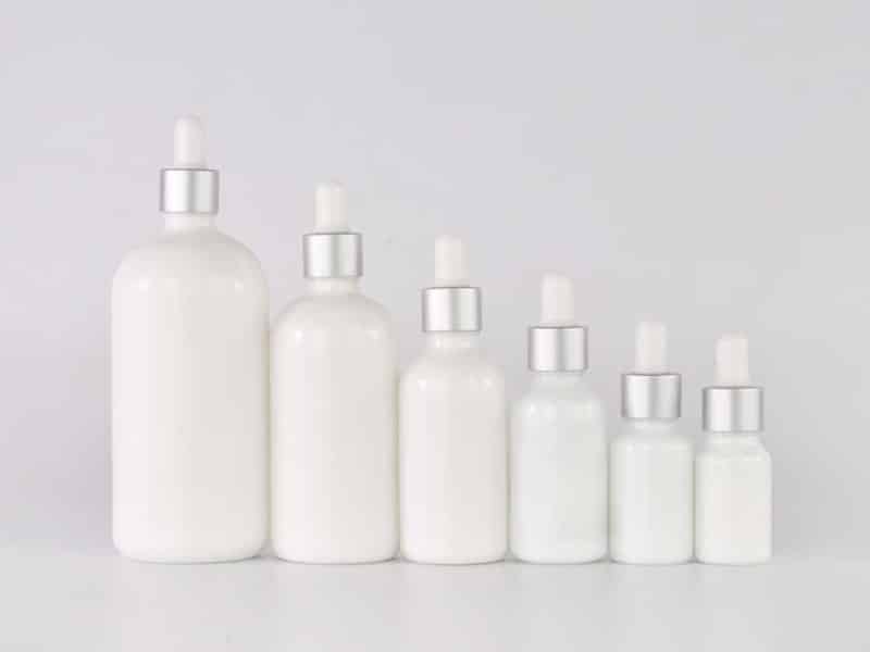 Set of white serum bottles with silver droppers