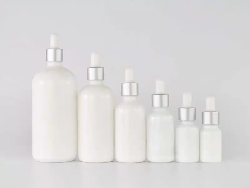 Set of white serum bottles with silver droppers