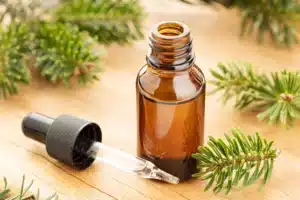 One of amber dropper bottles with essential oil and fir branches