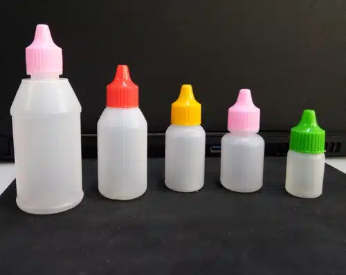 Five plastic dropper bottles of increasing size with colorful caps