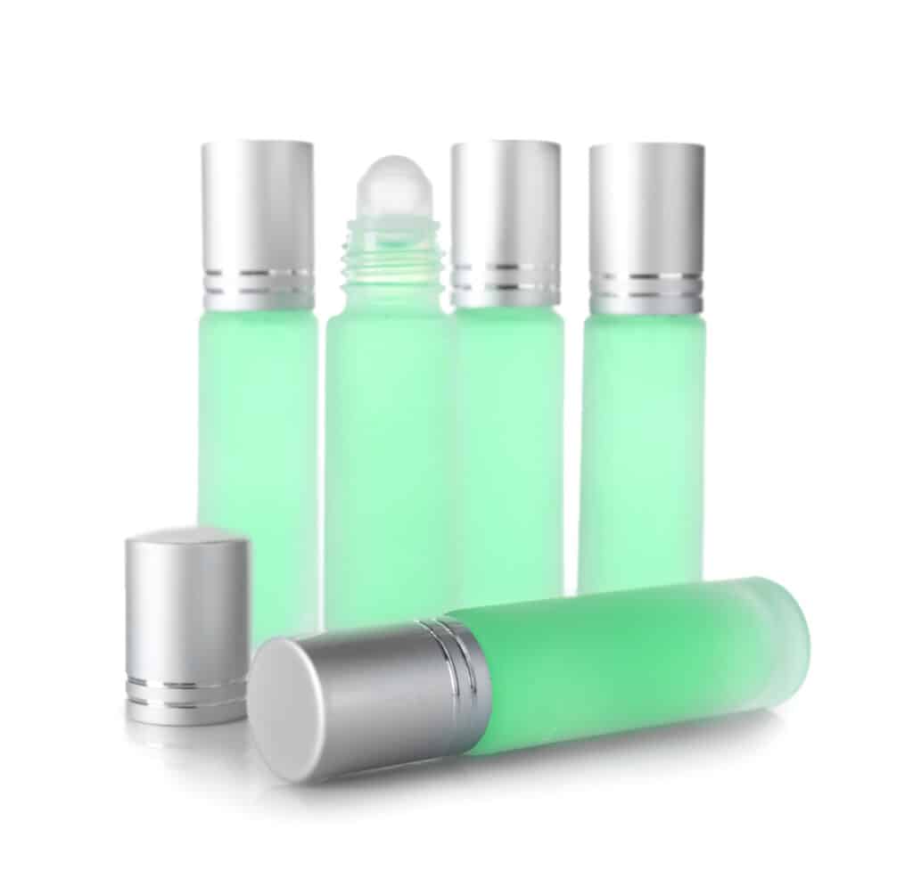 roller Bottles of modern perfume on white background